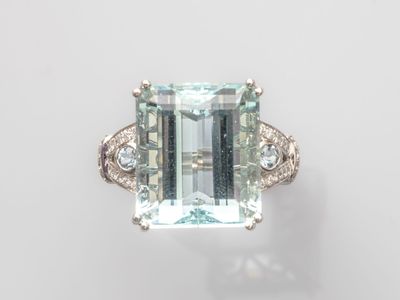 une bague sertie d'une aigue-marine et de diamants sur fond blanc