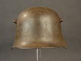 an old helmet on a metal stand on a gray background
