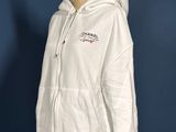 a white hoodie on a mannequin stand against a blue wall
