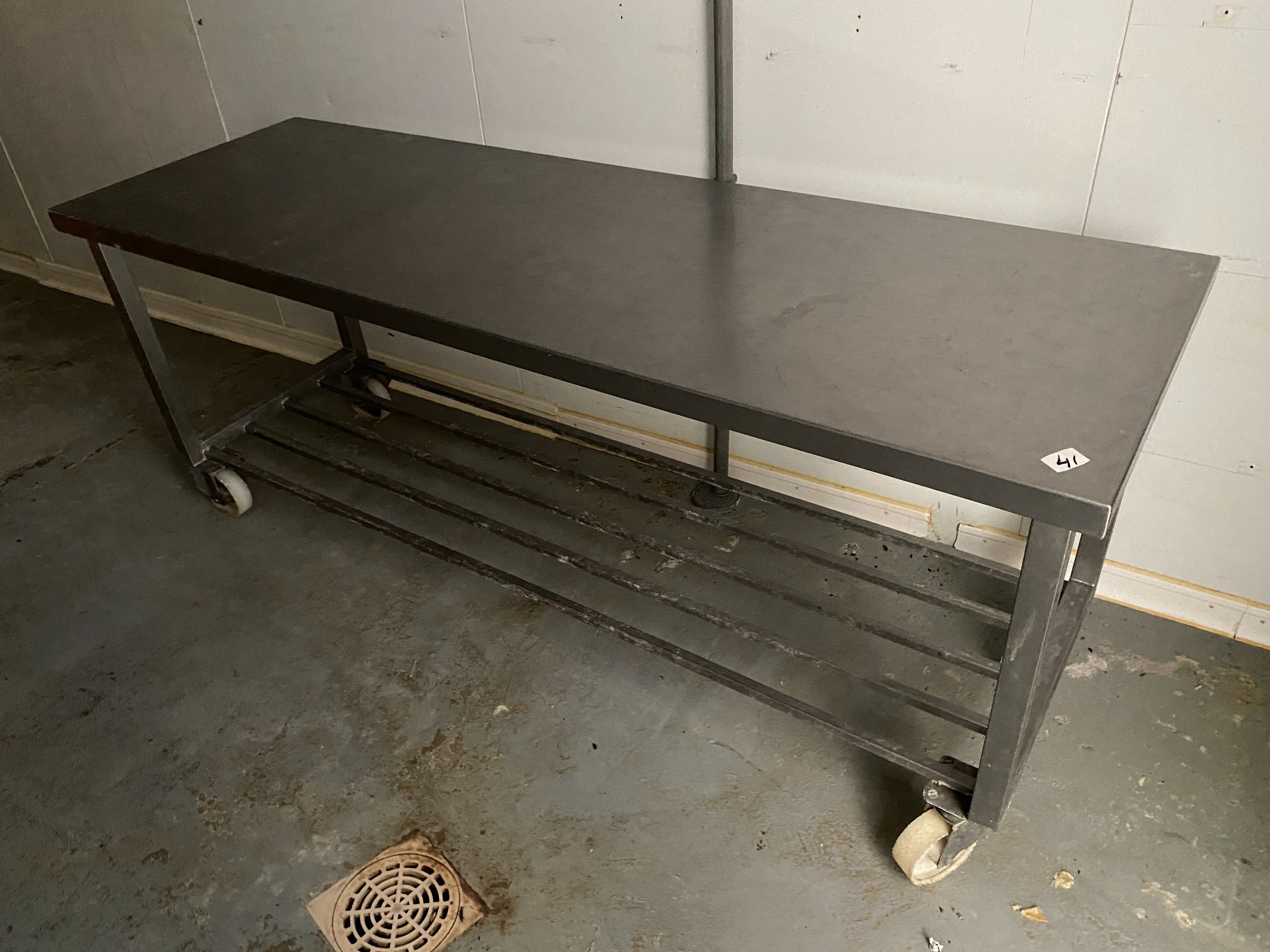 Une table rectangulaire en inox à claies d'entrejambe, sur r…