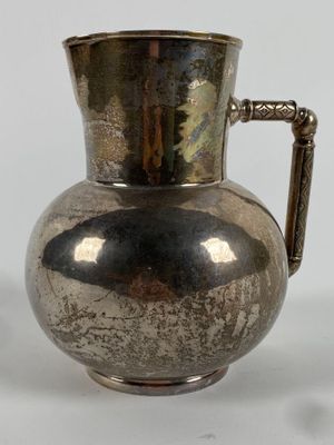 a silver pitcher that is sitting on a table