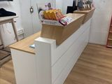 un comptoir blanc avec un plan de travail en bois et une échelle rouge en arrière-plan