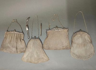 quatre petits sacs à main sont alignés sur une surface blanche