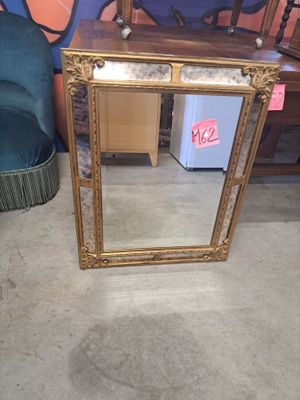 un miroir posé sur le sol à côté d'une chaise