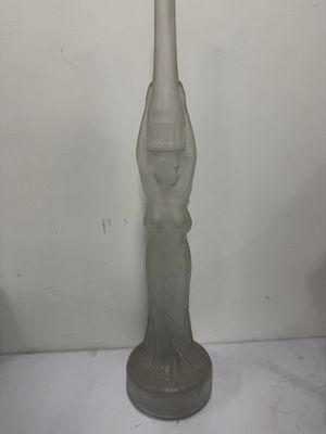 a glass vase that has a statue on it
