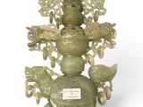 a green vase with a bird on top of it