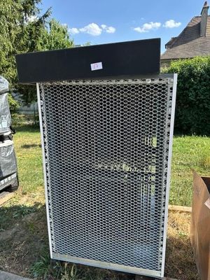 a large air conditioner sitting in a yard next to a pile of garbage