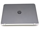 the back of a laptop with a silver cover on a white surface