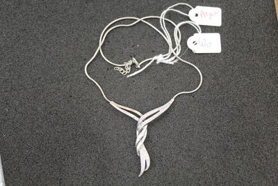 a silver necklace and earphones laying on the floor