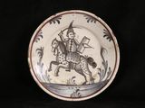 a plate with a picture of a man riding a horse