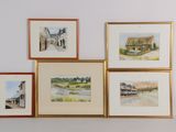 quatre tableaux accrochés au mur au-dessus d'un canapé