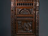 une vieille armoire en bois ornée de sculptures sur la façade