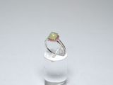 un gros plan d'une bague sertie d'un oplite vert