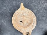 a small piece of pottery sitting on a table next to rocks