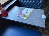 a table with a magazine on it and a blue chair in front of a window