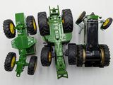a green toy tractor and a green toy tractor on a white surface