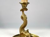 une lampe de table ancienne en laiton sur laquelle est posé un oiseau