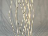une sculpture composée de bâtonnets blancs posés sur un socle noir