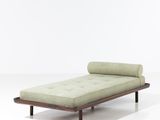 une chaise longue verte posée sur un sol blanc