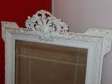 a mirror with a white frame and a red wall behind it
