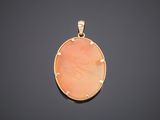 a yellow gold pendant with a pink stone in the center
