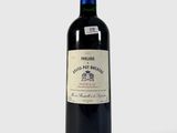 la bouteille de vin rouge est posée sur une surface blanche