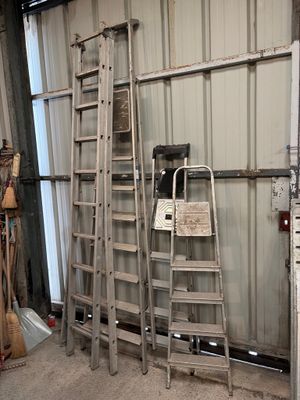 several ladders are leaning against a wall in a garage