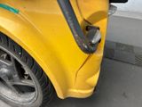 a close up of a yellow car with a black handle