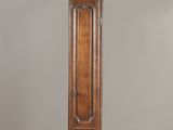 une grande horloge de parquet en bois surmontée d'un oiseau