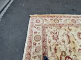 a person standing next to a rug on the street