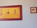 tableau accroché au mur d'une chambre où se trouvent un lit et un tableau accroché au mur