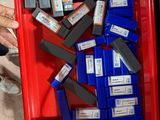 une boîte rouge remplie de piles et une personne tenant un téléphone portable
