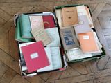 des cartons remplis de livres posés sur un parquet