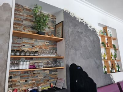 une pièce avec un mur en pierre et des étagères sur lesquelles sont disposées des plantes