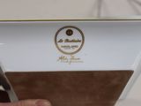 a person holding a white and brown plate with a logo on it