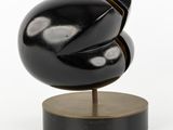 sculpture of a black sphere on a wooden base on a white background
