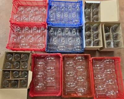boxes of empty wine glasses and bottles are sitting on the floor