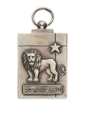 un gros plan d'un porte-clés en métal orné d'un lion