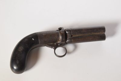 an old gun on a white surface with a black handle