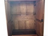 a wooden armoire with a drawer underneath it