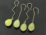 a set of four yellow jade tear earrings on a black background