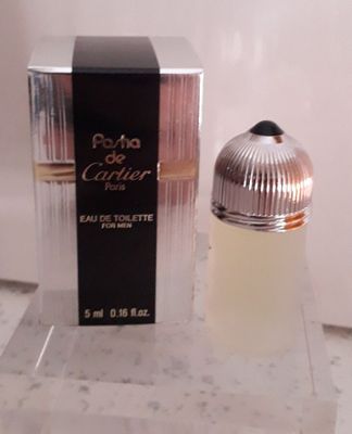 un flacon de parfum posé sur un comptoir à côté d'une boîte de parfum