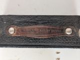 an old black leather case with a brown leather label on it