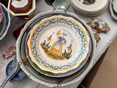 de nombreuses assiettes et bols posés sur une table recouverte d'une nappe blanche