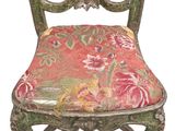 an old chair with a floral upholstered seat on a white background