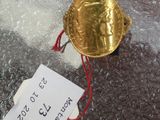 a gold coin on a plastic bag with a price tag on it