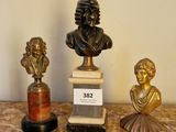 trois bustines en bronze posées sur une table en marbre dotée d'un socle en marbre