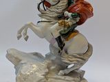 a figurine of a man riding a horse on a rock