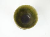 a small green bowl on a table with a white background
