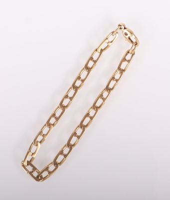 gros plan d'un bracelet en chaîne en or sur fond blanc
